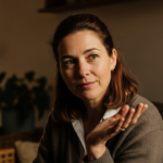 Photograph of a composed confident woman setting a calm boundary in a conversation, warm natural light, empowering