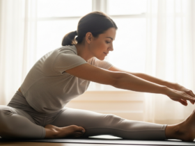 Calm lifestyle photograph of a woman doing gentle yoga stretching by a bright window in the morning, hormone-balance wellness mood, soft natural light